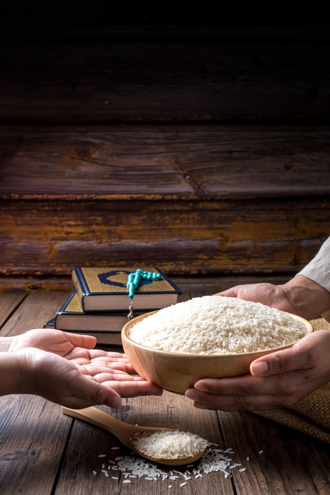 Hands,Holding,A,Wooden,Bowl,Of,Rice,Grains,For,Zakat,