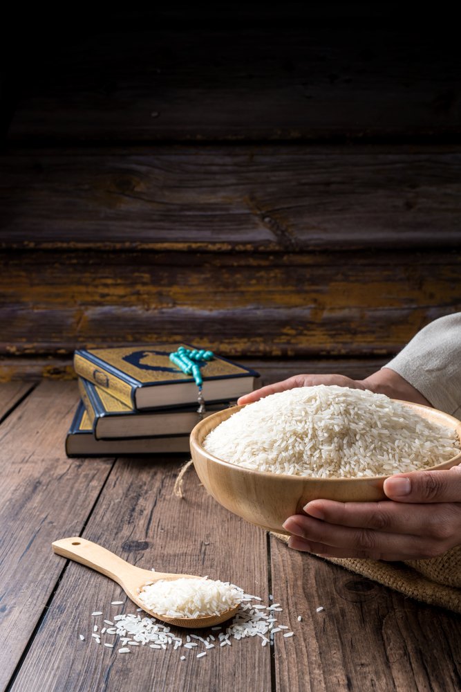Hands,Holding,A,Wooden,Bowl,Of,Rice,Grains,For,Zakat,