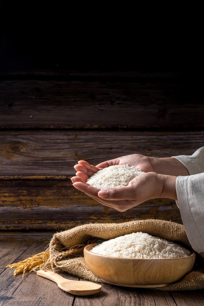 Hands,Holding,A,Wooden,Bowl,Of,Rice,Grains,For,Zakat,