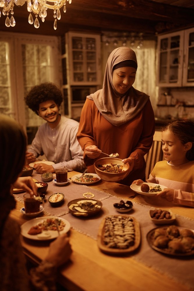 Happy,Middle,Eastern,Grandmother,Serving,Food,To,Her,Family,At
