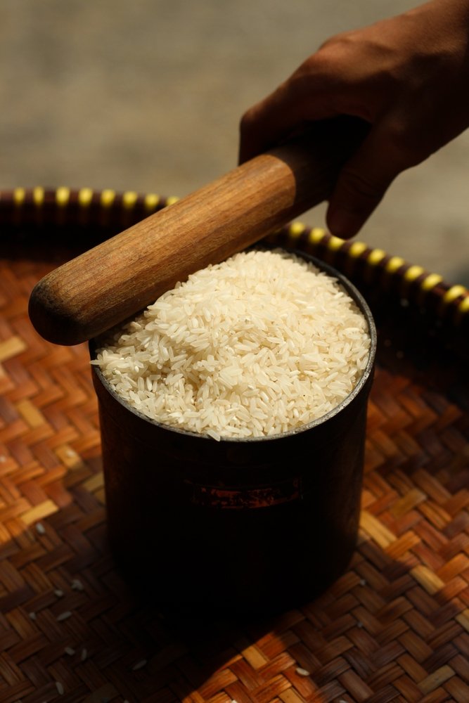 A,Hand,Are,Measuring,Rice,In,Liters.